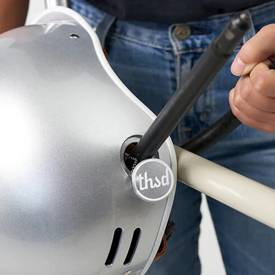 Image of the Thousand Heritage 1.0 Helmet in So Silver being secured to a bike using the Secret PopLock.