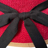 Close up of a red hat with a black ribbon.