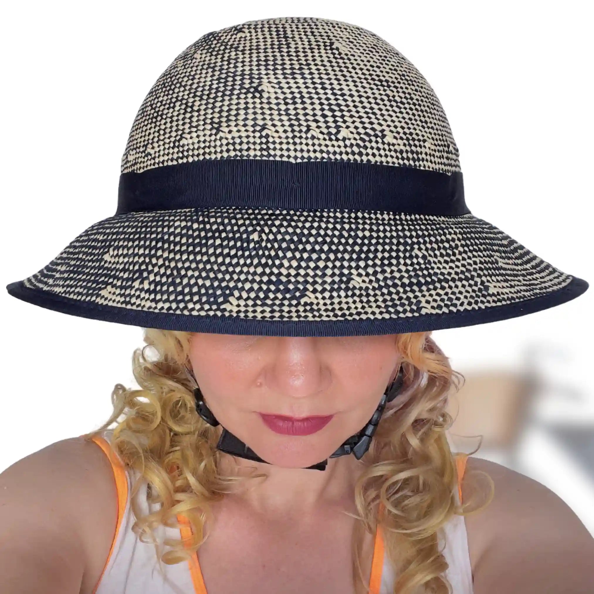 Woman wearing the Shibori Blue Straw Hat Bike Helmet, showing the front view and wide brim.