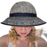 Woman wearing the Shibori Blue Straw Hat Bike Helmet, showing the front view and wide brim.